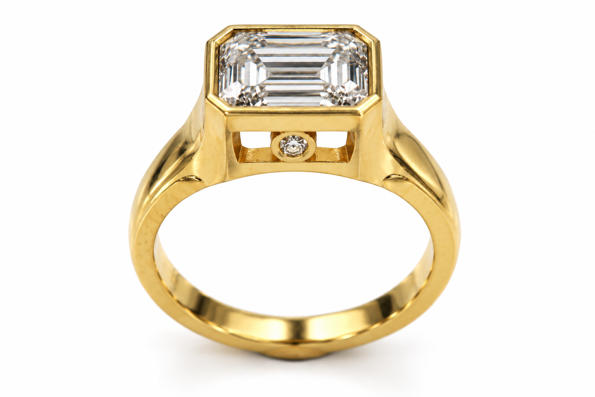18ct yellow gold ring with an emerald-cut centre stone, shown on a white background